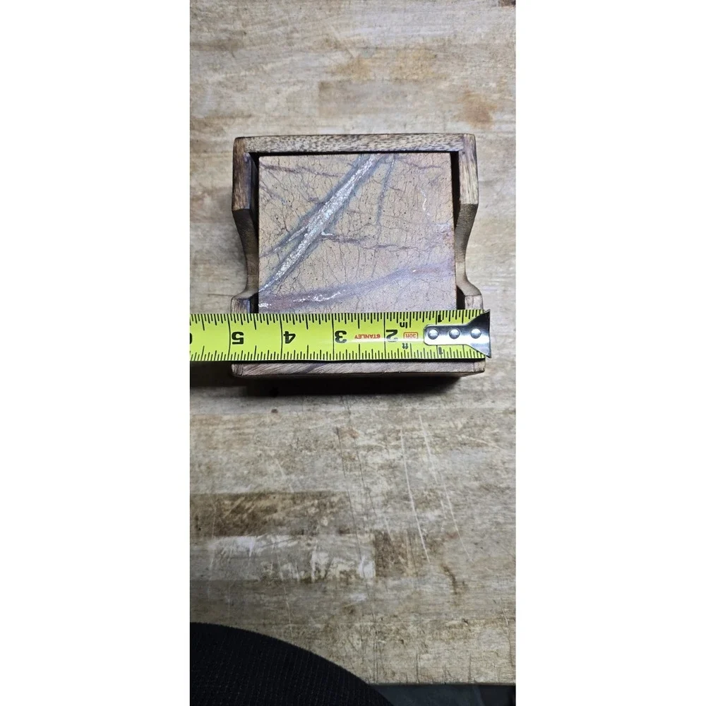 square marble coaster set holder in a wooden base.